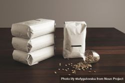 Pouches of coffee beans with blank label with spilled glass of whole beans 5RZGB5
