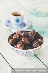 Bowl of dates with espresso and water in background 56NrY5