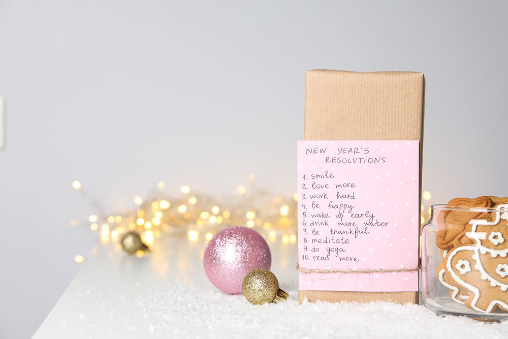 Cookies in jar and paper with list on box on light background, space for text
