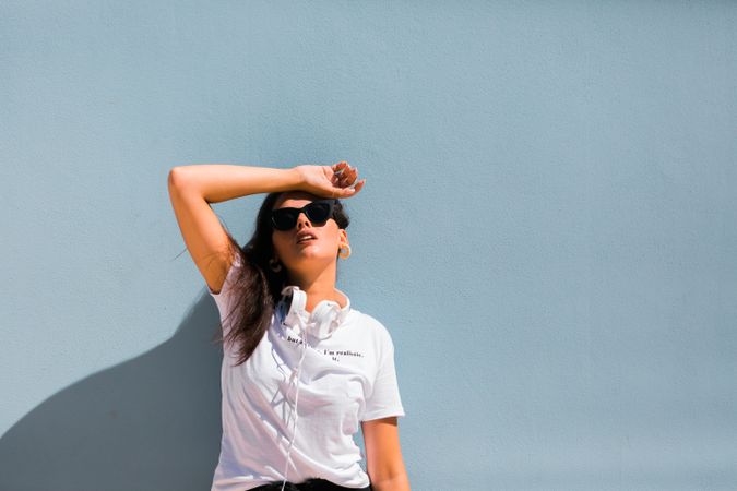 Cheerful casual woman in sunglasses standing on city street