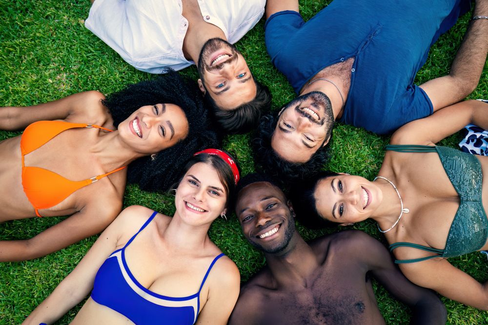 Multi-ethnic friends lying on grass in park