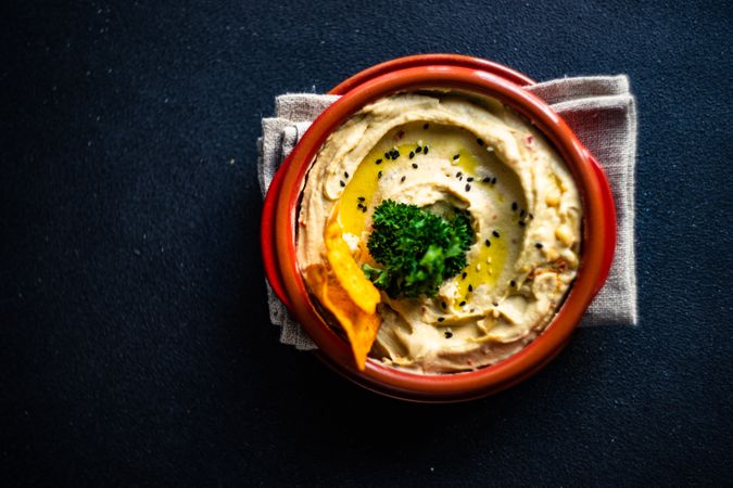 Looking down at creamy hummus dip with swirl of olive oil