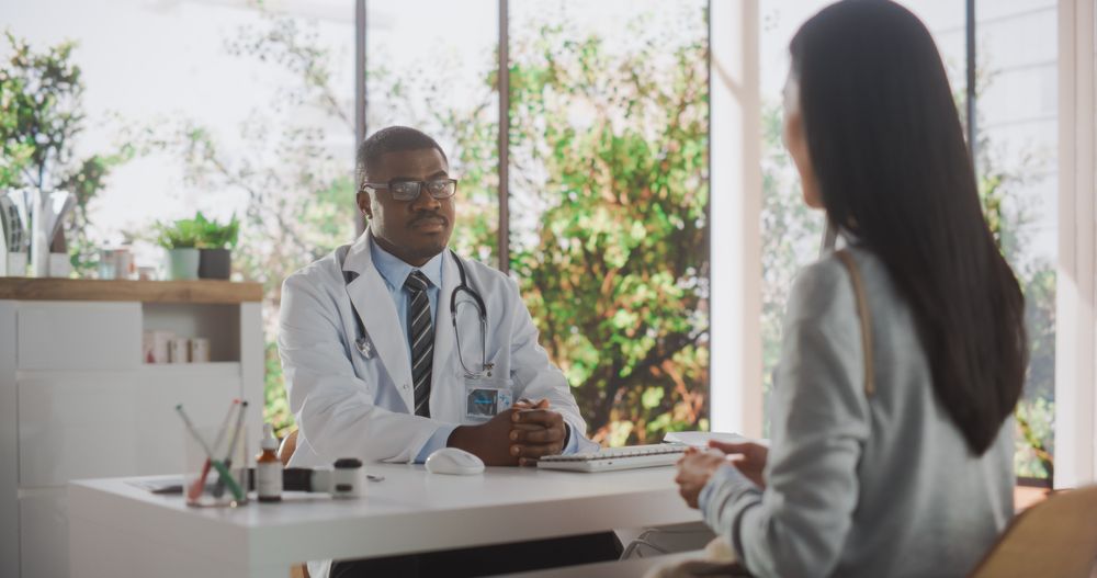Black Doctor Speaking to an Anonymous Patient During a Consultation in Health Clinic.