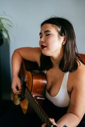 Young woman in repose holding guitar