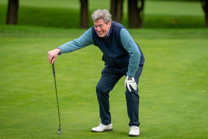 Man checking shot on golf course