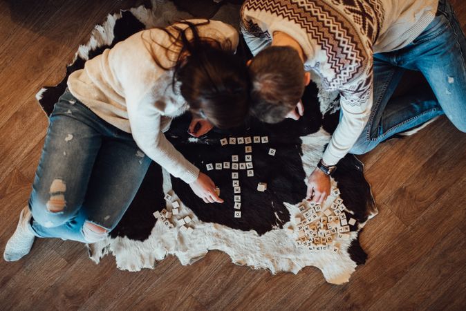 Man and woman playing board game on floor