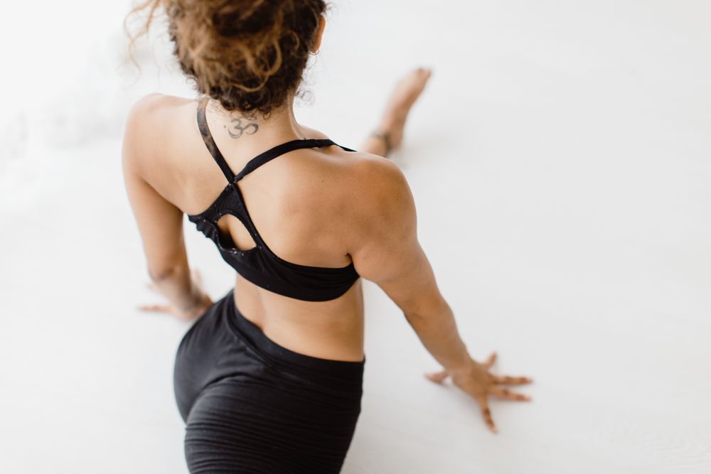 Sportive woman performing yoga pose in room