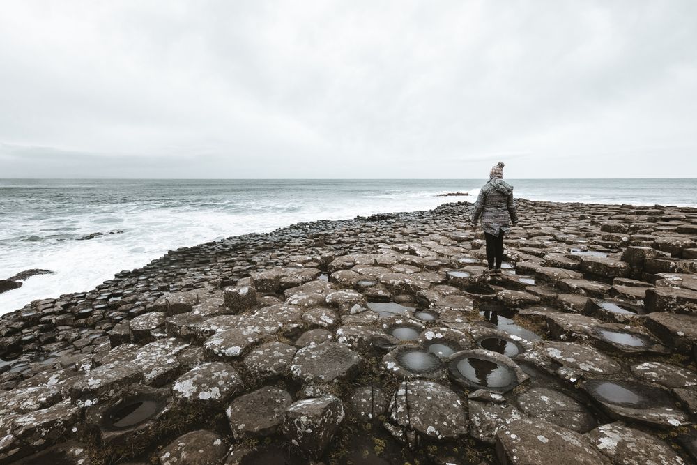 Female standing on cliff and contemplating