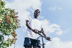 Black man riding on electric scooter in park