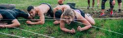 Participants in an obstacle course crawling
