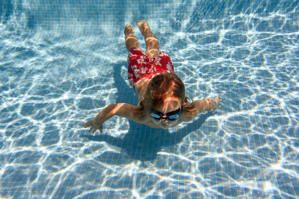 Boy swimming near bottom in pool