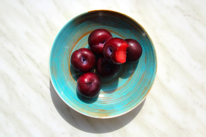 Ripe juicy plums in blue vintage plate