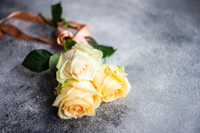 Yellow flowers on grey counter wrapped in peach ribbon
