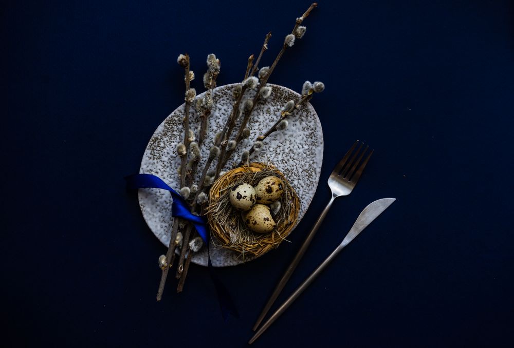 Top view of blue table and bird's nest on grey table for Easter table setting