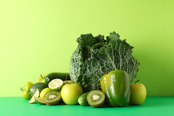 Vegetables and fruits on green background, copy space