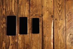 Three cellphones laying on table
