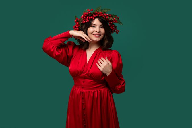Woman in red dress wearing berry wreath