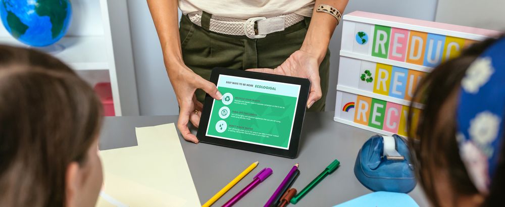 Teacher showing tablet with tips to be more ecological for students in environmental classroom