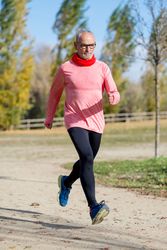 Older male with grey hair sprinting in park
