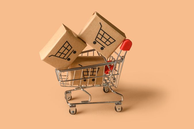 Shopping Cart with Small Boxes Represents Online Retail and Delivery