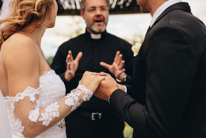 Bride and groom getting married in front of a priest