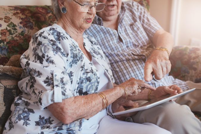 Close up shot of older couple at home using digital tablet