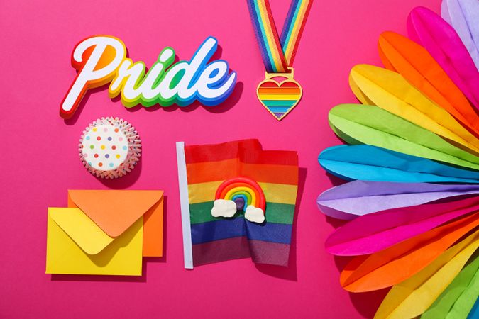 Pride parade concept, holiday symbols on pink background.