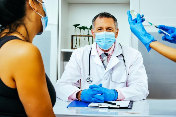 Medical assistant preparing injection for patient in doctor’s office