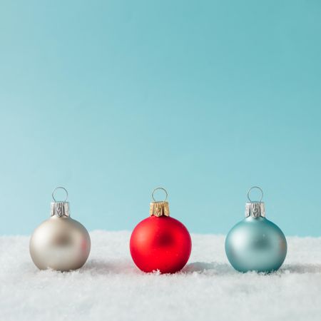 Row of Christmas bauble decorations on snow