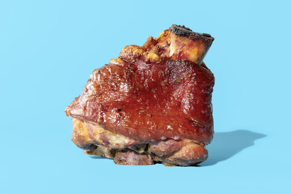 Roasted pork knuckle minimalist on a blue background