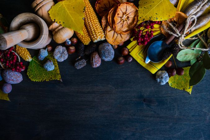 Autumn flatlay with nuts, berries, vegetable and fruits on dark wooden background with copy space