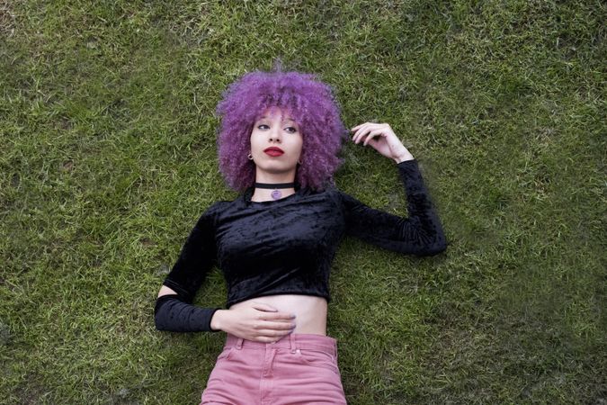 Woman in colored shirt lying on grass