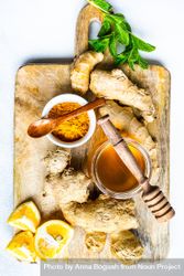 Top view of raw ginger, turmeric & honey on cutting board 4Az3rz