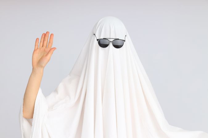 Concept of Halloween, Ghost with sunglasses on light background