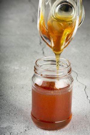 Honey in glass jar on the table.