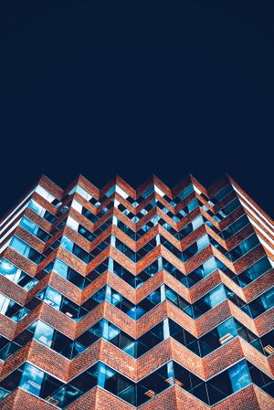 Top part of high rise symmetrical blue and red building