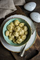Top view of bowl of Russian dumplings with salt and pepper shakers
