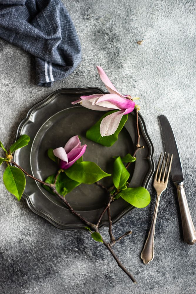 Top view of dark plate with magnolia branch