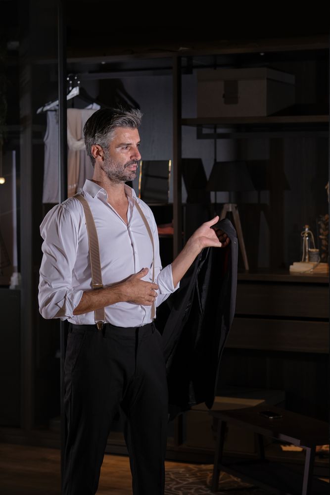 Mature person standing with jacket in hand