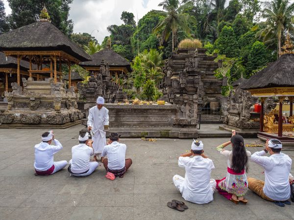 Bali, Indonesia - August, 15 2015: People praying on temple yard
