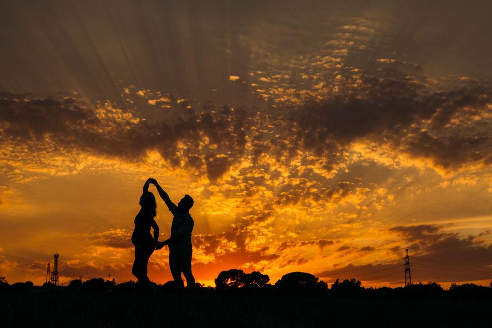Anonymous couple dancing during sunset