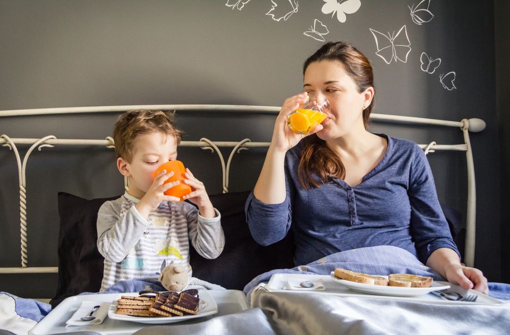 Mother and son having breakfast in bed