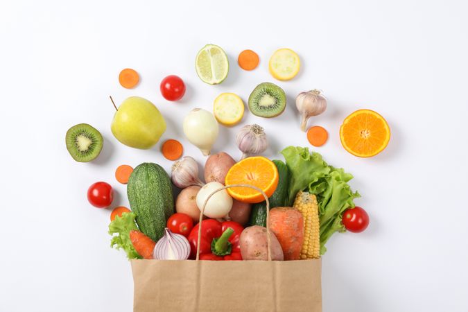 Flat lay with paper bag, vegetables and fruits on background, copy space