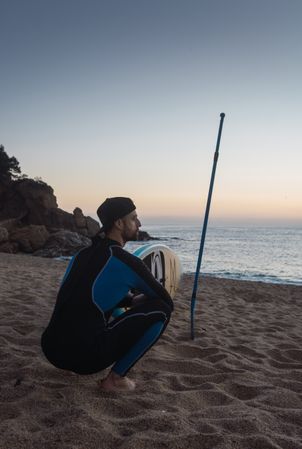 Man practicing paddle surfing with neoprene in a sunrise