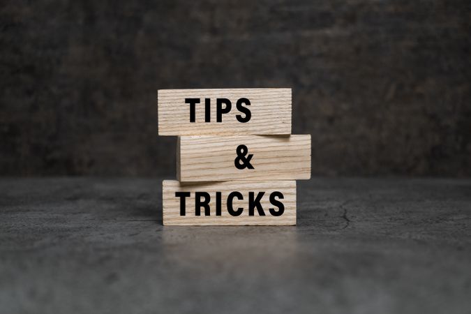 tips and tricks words on wooden blocks isolated on dark background