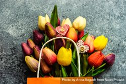 Valentine's day concept with heart shaped ornaments scattered on fresh tulips on grey counter bxAAjy