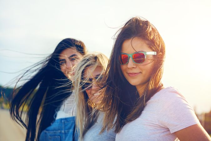 Female in reflective sunglasses on sunny day with friends