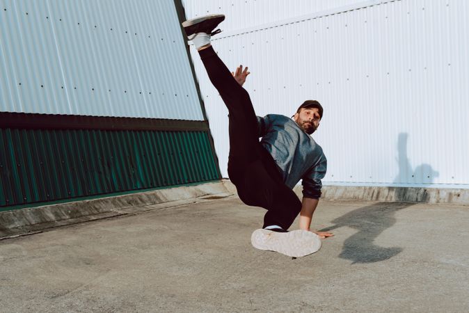 Man performing handstand near wall