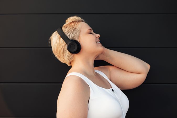 Side view of woman with eyes closed listening to headphones