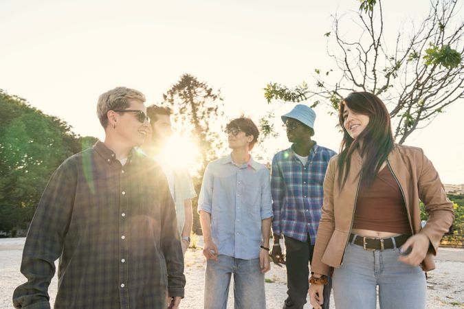 Candid shot of a diverse group of friends walking and talking together outdoors.